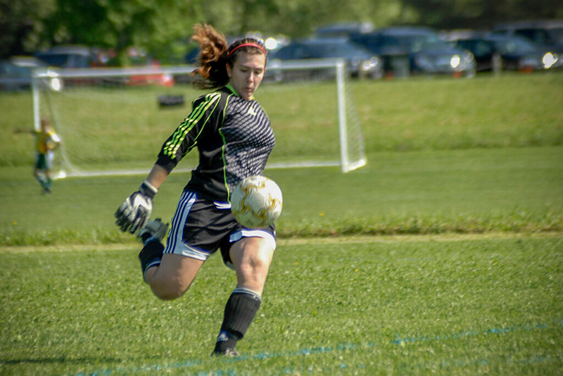 girl kicking a soccer ball